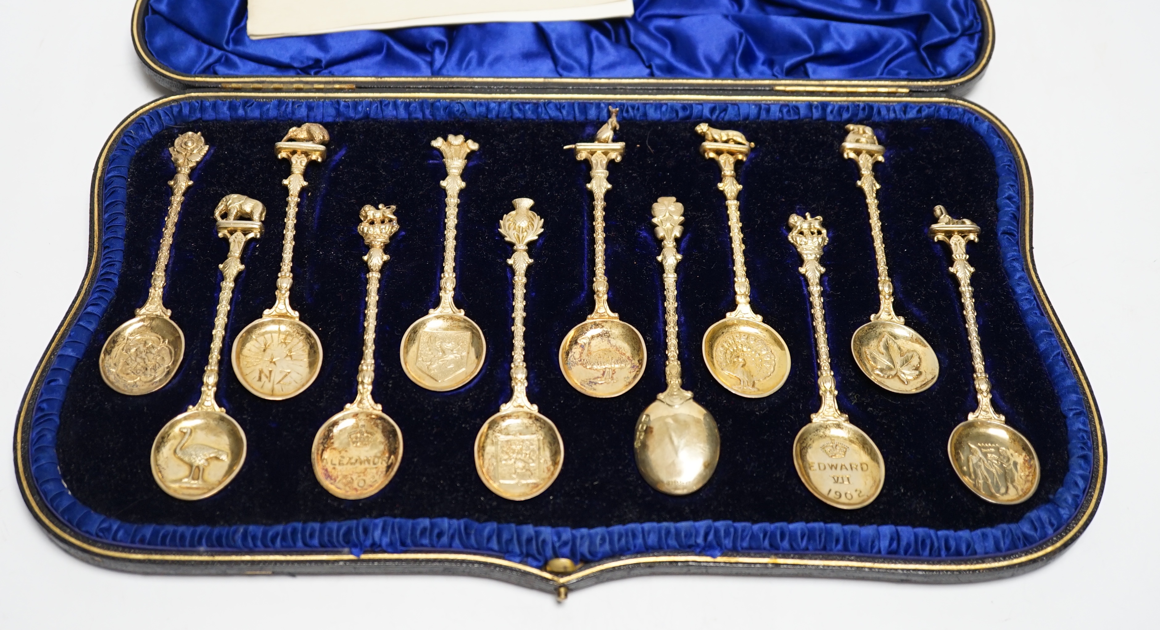 A set of twelve Edwardian silver gilt 'Greater Britain' souvenir spoons, Edward Barnard & Sons, London, 1902, 12.1cm, 8.4oz.